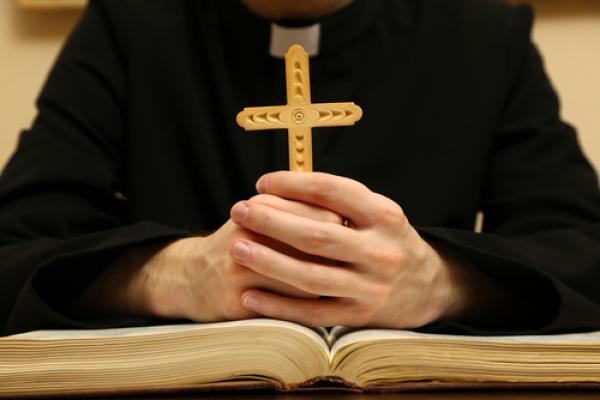 Priest reading from the Bible,  Africa Studio / Shutterstock.com