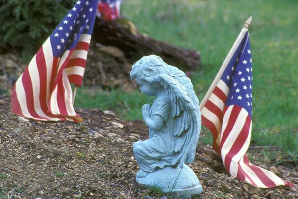 Close-up of a statue and an American flag, Purestock / Getty Images
