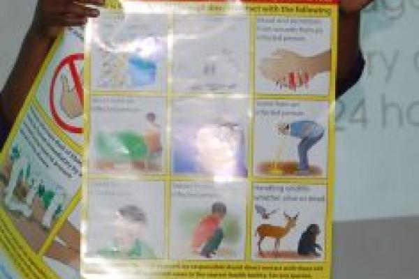 The Rev. Pauline Njiru, of Kenya displays a poster showing how Ebola can be tran