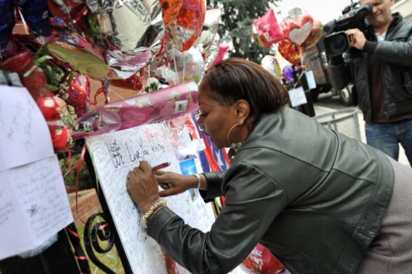 Fan signs a poster for singer Whitney Houston at the New Hope Baptist Church, Ne