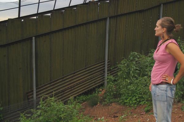 Maryada Vallet stands in Nogales, Mexico, pondering this wall.