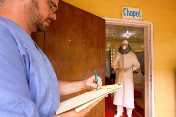Kent Brantly of Samaritan’s Purse, right, gives orders for medication. Ima