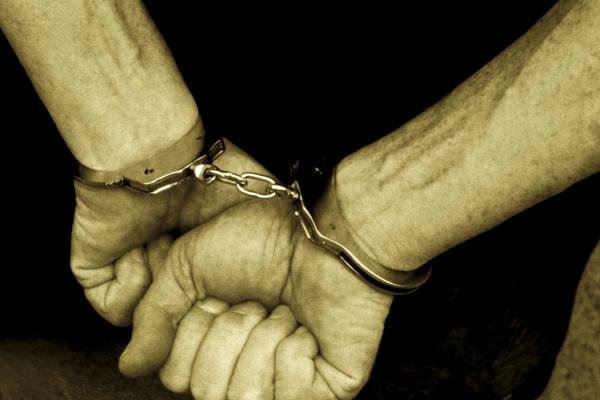 Hands in handcuffs, Digital Vision. / Getty Images