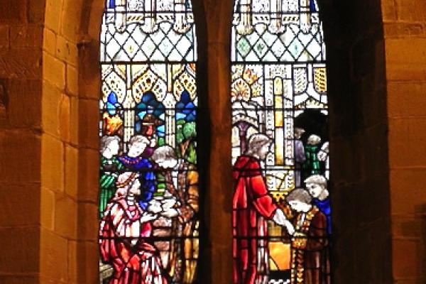 Stained glass church window depicting the Parable of the Talents from Matthew 25