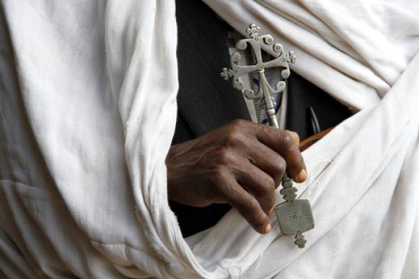 Hand holding Coptic cross.