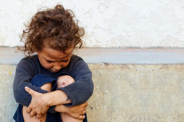 A child sits alone. Image via Olesia Bilkei/shutterstock.com