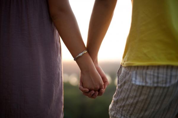 A couple holding hands. Image via Mirko Tabasevic/shutterstock.com