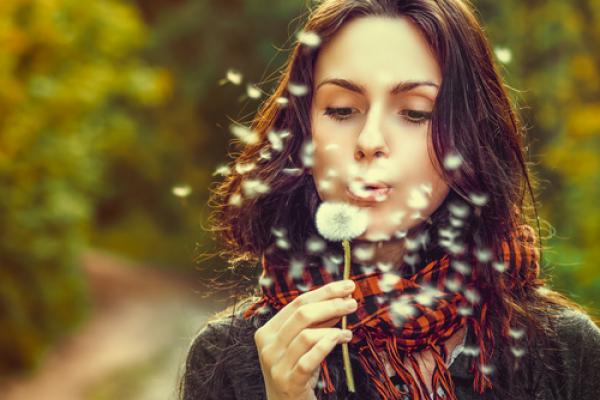 Girl blowing on dandelions, Volodymyr Goinyk / Shutterstock.com