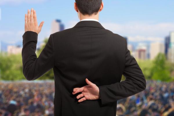 Politician swearing oath with fingers crossed, Minerva Studio / Shutterstock.com