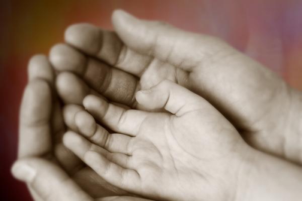 Child hand inside a parent's, mickyso /Shutterstock.com