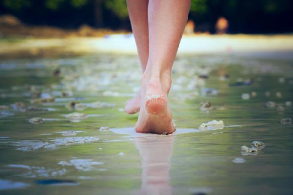 A woman walking on sand. Image courtesy Nikolay Bassov/shutterstock.com.