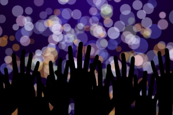 Hands streteched toward lights, pukach / Shutterstock.com
