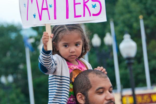 A young girl joins a rally against racism in Washington, DC in August 2014. Imag
