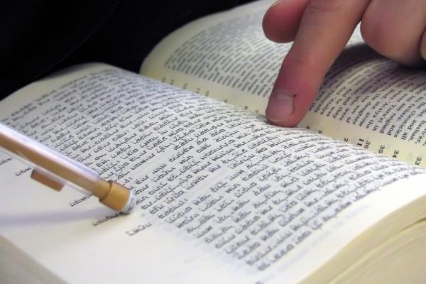 Student pointing at bible, Nir Levy/Shutterstock.com.