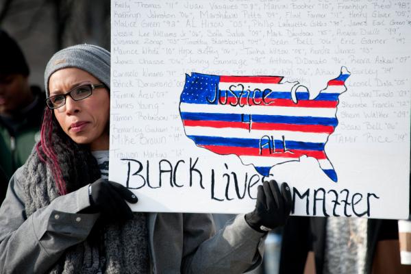 Woman holds a 'Black Lives Matter' sign. Image courtesy Rena Schild/shutterstock