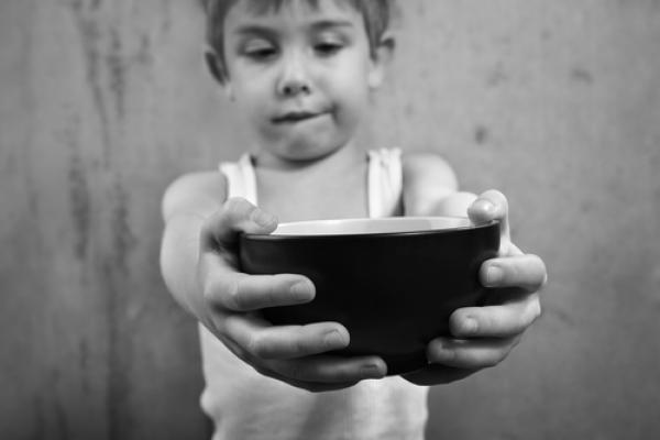 Child holding empty bowl, Suzanne Tucker / Shutterstock.com