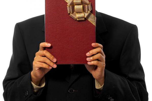 Man wearing black holds a gift. Image courtesy Man wearing black holds a gift. I