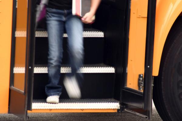 Youth getting off a school bus,  Margie Hurwich / Shutterstock.com