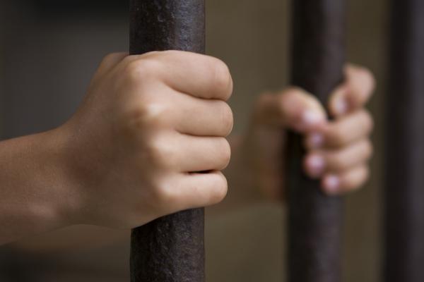 Child behind bars photo, pjcross, Shutterstock.com