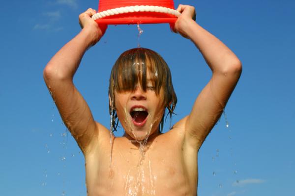 A child dumps ice water over his head. Image courtesy Suzanne Tucker/shutterstoc
