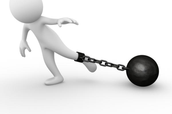 Ball and chain holding person back, Air0ne / Shutterstock.com