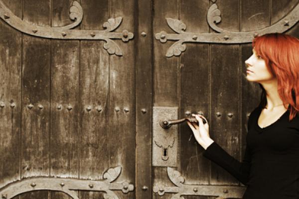 Photo: Young woman near church doors, Lisa A / Shutterstock.com