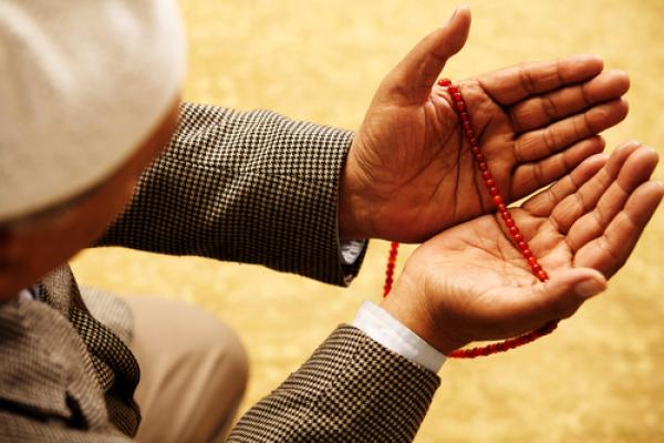 Hands with Muslim prayer beads, Omer N Raja / Shutterstock.com