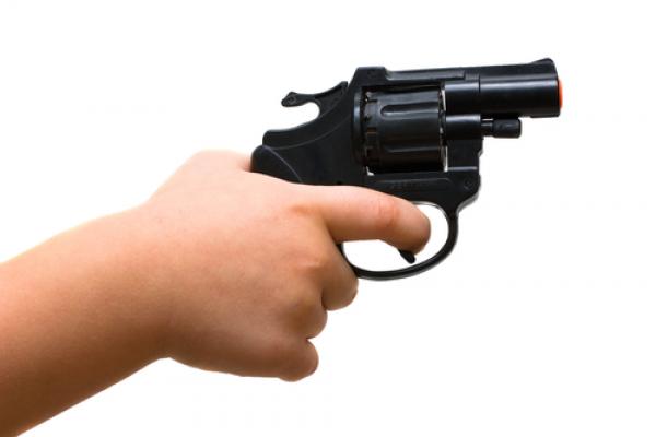 A child points a gun. Image courtesy Marek H./shutterstock.com