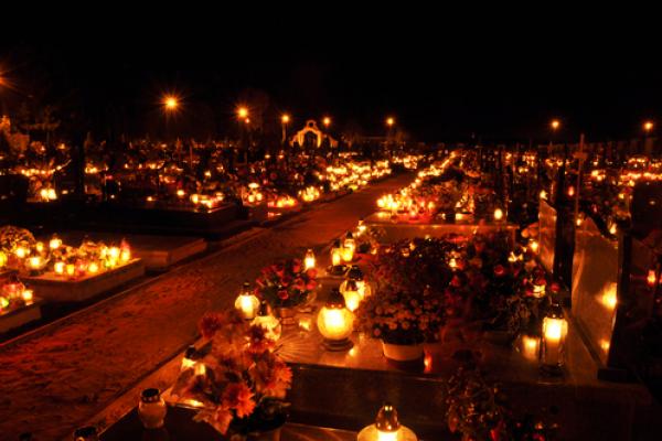 Candles illuminate a cemetery on All Saints' Day, wawritto / Shutterstock.com