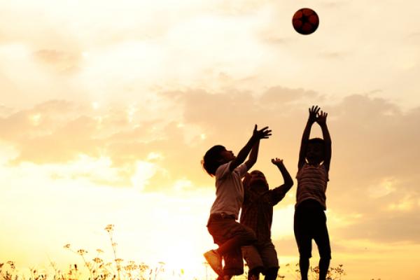Children playing with a ball at sunset. Image courtesy Zurijeta/shutterstock.com
