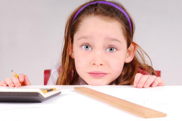 Girl working on math homework. Image by Cheryl Casey/Shutterstock.com.
