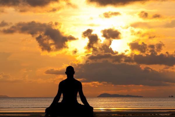 Man silhouette doing yoga, aragami12345s / Shutterstock.com