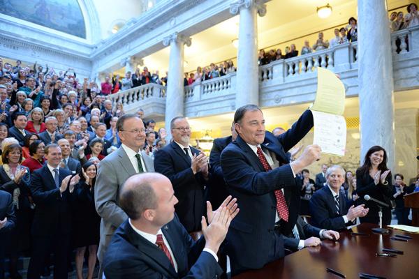 Utah Gov. Gary Herbert displays Senate Bill 296 after signing it into state law.
