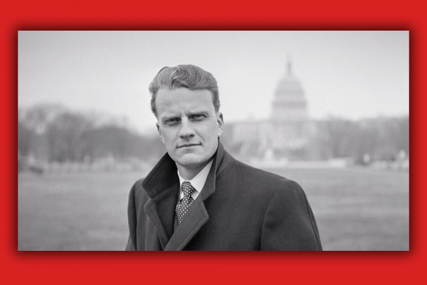 Billy Graham looks straight into the camera with the US Capitol building behind him.