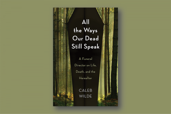Book cover: A black background in the shape of a coffin is framed by a green light silhouetting trees with brown trunks and no branches in the shape of curtains; white text on black reads "All the Ways Our Dead Still Speak"