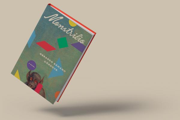 The book ‘Monstrilio’ is at an angle hovering in the air. Various shapes of different colors are spread across a gray-green background on the cover. A small brown creature with round red eyes and pointy ears is visible in the lower center of the cover.