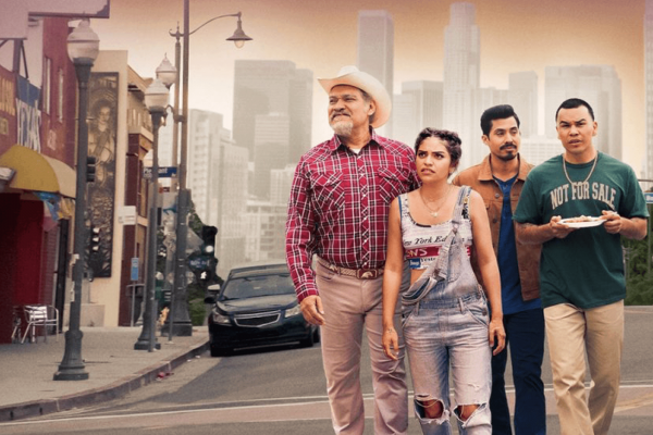 The Morales family in the show Gentefied stand on a street in Los Angeles. 