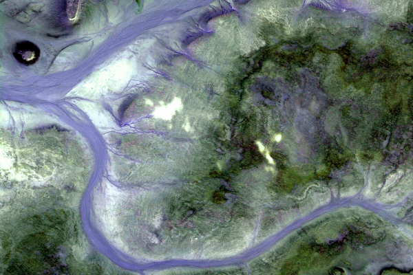 An aerial view of two rivers flowing around a green area of land