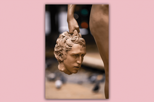 Detail from Luciano Garbati’s sculpture called "Medusa With the Head of Perseus." A golden arm and hand of Medusa holds the head of Perseus by his curly hair.