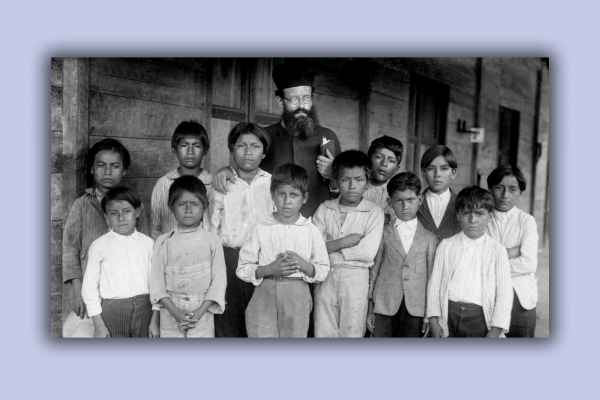In this vintage photo, a bishop of a church stands among Indigenous children, a scene from 'Exterminate All the Brutes.'