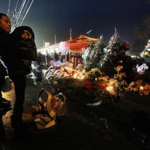 Isabel Lebron holds son Izaiah Taylor at a memorial with donated Christmas trees honoring victims. Mario Tama/Getty Images Mario Tama/Getty Images