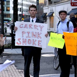 A Pink Smoke rallier holds a sign during prayers in downtown Washington, DC. Photo courtesy Ted Majdosz.
