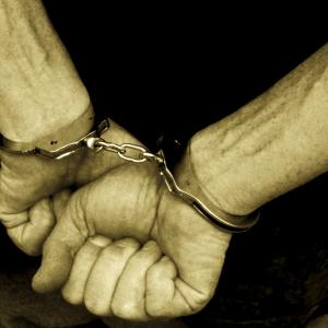 Hands in handcuffs, Digital Vision. / Getty Images