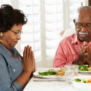 Couple praying at mealtime, Monkey Business Images / Shutterstock.com