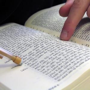 Student pointing at bible, Nir Levy/Shutterstock.com.