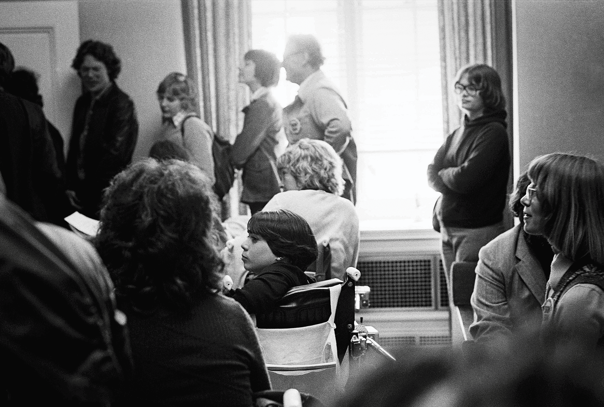 Black and white photo of young activists facing the front of a government room