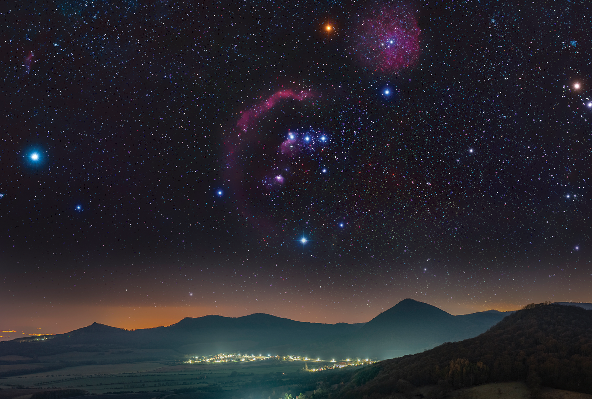 Orion glitters above mountains as the last of the sun sets