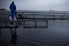 A man watches the waves in New York Harbor from Battery Park, New York City. Andrew Burton/Getty Images Andrew Burton/Getty Images