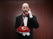 Butler with a red telepfone on a silver tray. Photo via Getty Images. Butler with a red telepfone on a silver tray. Photo via Getty Images.