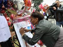 Fan signs a poster for singer Whitney Houston at the New Hope Baptist Church, Newark, New Jersey. Photo by STAN HONDA/AFP/Getty Fan signs a poster for singer Whitney Houston at the New Hope Baptist Church, Ne
